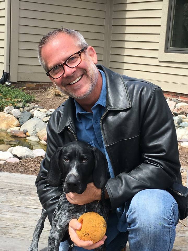 Ted Trepinski with a dog, holding an orange ball